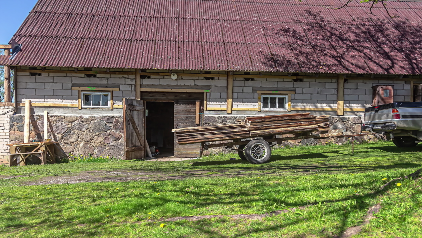 Putting reclaimed cedar siding on a home - time lapse with shadows from a tree crossing the scene