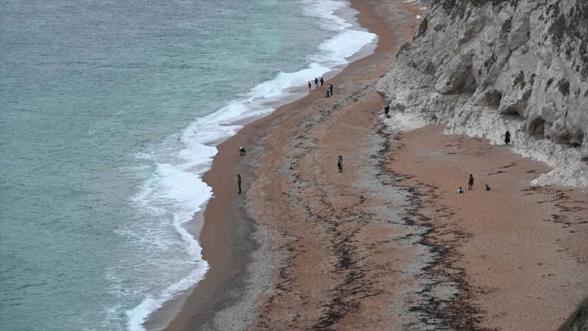 Dorset beach, elevated shot with people looking at the sea.