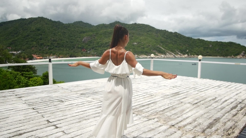 a girl in a white dress dancing