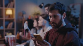 Concentrated bearded man looking attentively at his device screen and rejoicing while looking at results of sports betting during football game. Male fans cheering at home concept - Powered by Shutterstock - Get 15% off with code: PIKWIZARD15