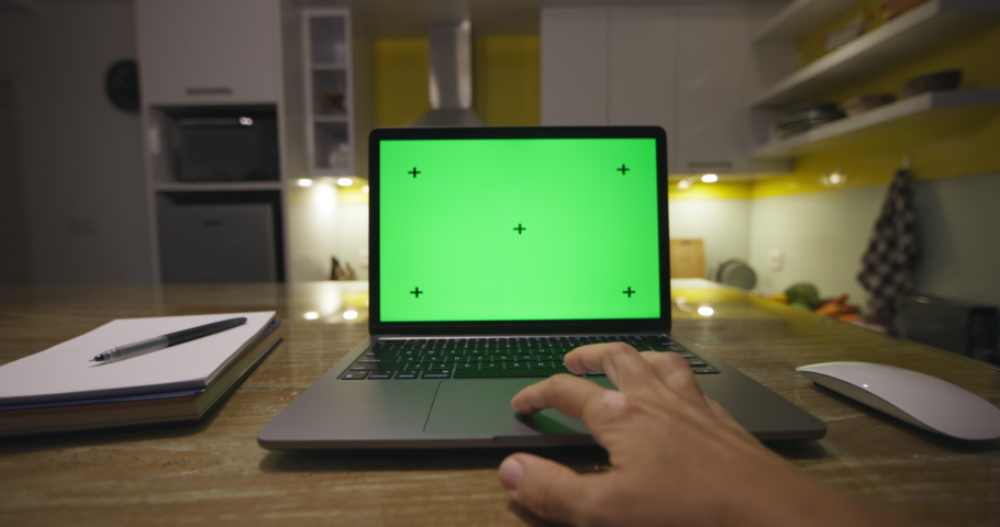 Laptop with green screen. Female hands typing and scrolling on a track pad, modern kitchen background. Dolly in. Perfect to put your own image or video. Track points with perspective corner pin Royalty-Free Stock Footage #1097723893