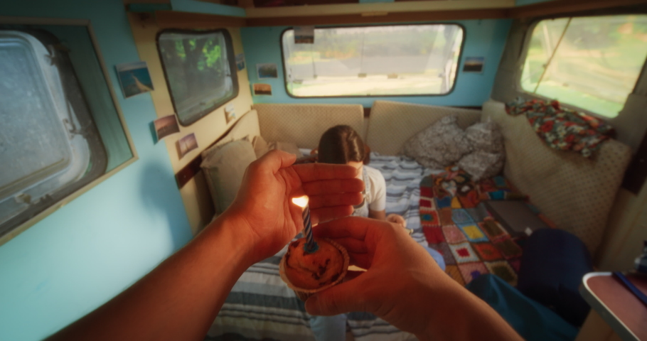 Caring Partner Bringing a Birthday Cupcake Muffin with a Candle to His Beautiful Young Girlfriend. Loving Tourist Couple Living in a Caravan, Road Tripping Across the Country and Camping. POV Footage Royalty-Free Stock Footage #1097724195
