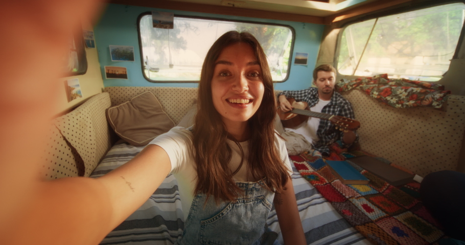 Beautiful Young Female Having a Video Call with Family or Friends from a Vacation Camping Motorhome Spot. Girl Waving to Say Hello and Asking Her Boyfriend to Join the Conversation. POV Footage. Royalty-Free Stock Footage #1097724203