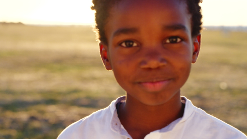 Black child, boy and face at sunset in nature park, Congo garden or sustainability environment on school trip. Portrait, zoom and happy smile for kid, climate change accountability or responsibility Royalty-Free Stock Footage #1097726633