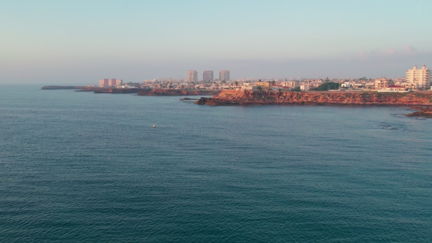 Seaside city at sunrise in top view.