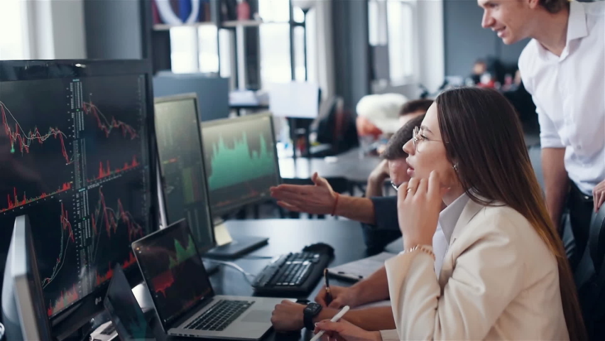 Side view. Group of stock traders working in the office with exchange technology. Analyzing graphs on the screens. Royalty-Free Stock Footage #1097734589