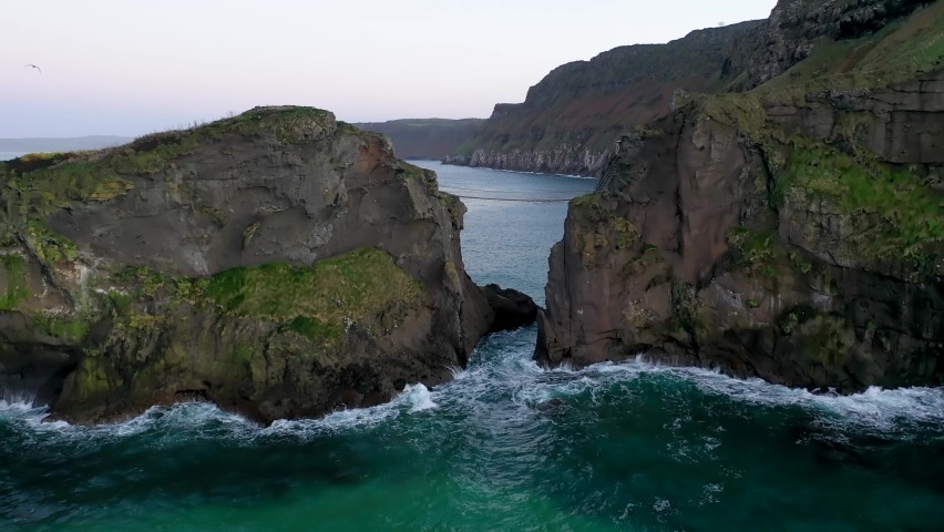 The Carrick-a-Rede Rope Bridge, near Ballintoy in County Antrim. Linking mainland the island of Carrickarede. Nothern Ireland, UK Royalty-Free Stock Footage #1097734997