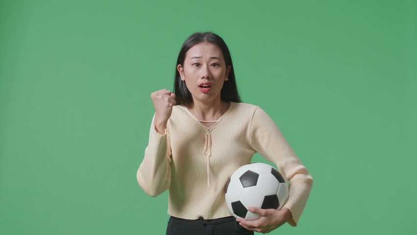 Asian Woman With A Ball Is Rooting For Shooting At Goal And Regretting While Cheering Soccer On Green Screen Background
