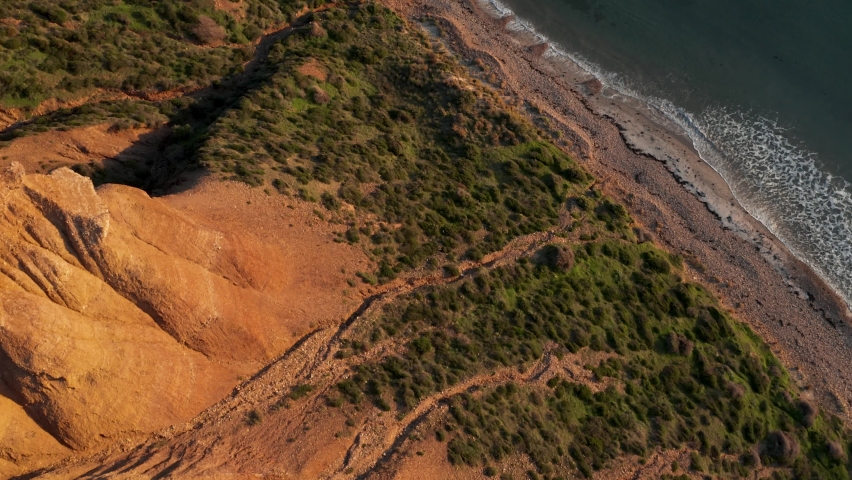 Sellicks Beach aerial reveal of ocean and cliffs at sunset golden hour, Fleurieu Peninsula, South Australia Royalty-Free Stock Footage #1097738523