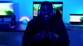 Young african boy wearing headset while playing online video games  