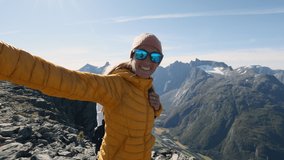 Woman hiking in Norway takes a selfie at mountain top. Travelling in Norway 