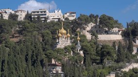 The Russian Orthodox Church of St. Mary Magdalene among the trees of the Garden of Gethsemane on the background of buildings in Jerusalem. - Powered by Shutterstock - Get 15% off with code: PIKWIZARD15