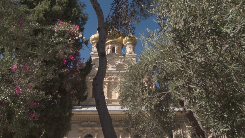 View of the magnificent building of the Church of St. Mary Magdalene through the flowering trees. Jerusalem, Israel.
