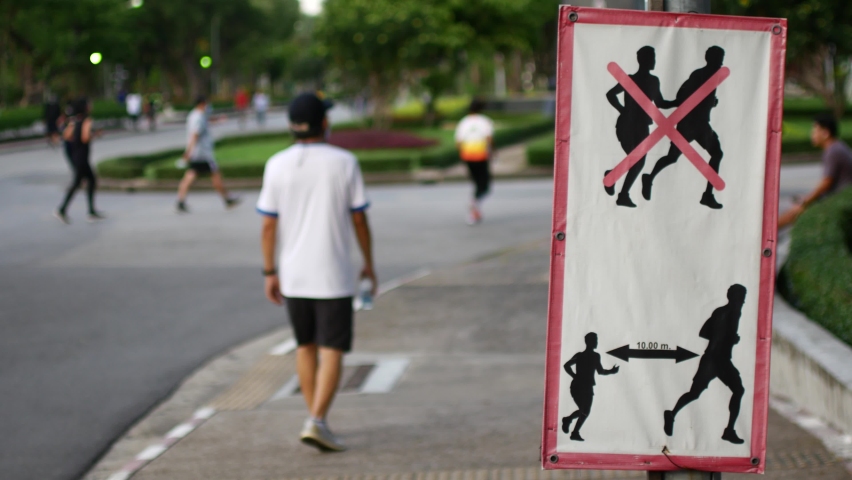 Sign encouraging social distancing while running in the park