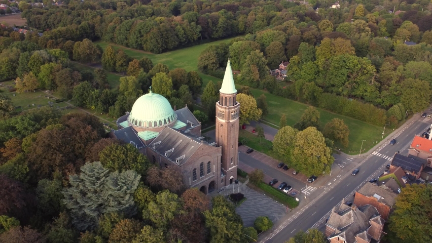Our Lady of Lourdes Church Basilica of Edegem, Antwerp in beautiful afternoon light. Aerial view of treetops and church