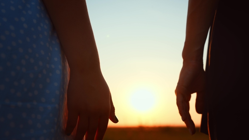 Close-up romantic view of couple holding hands against blurred sky and sunset. Relationships, support and love. Overcoming difficulties. Happy family travel. Date on outdoors nature landscape. Royalty-Free Stock Footage #1097754257