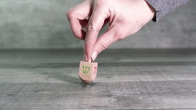 Hand twists a dreidel with the letters Shin, Hey, Nun and Gimel (Hebrew). Hanukkah. Jewish holidays (151) - Powered by Shutterstock - Get 15% off with code: PIKWIZARD15