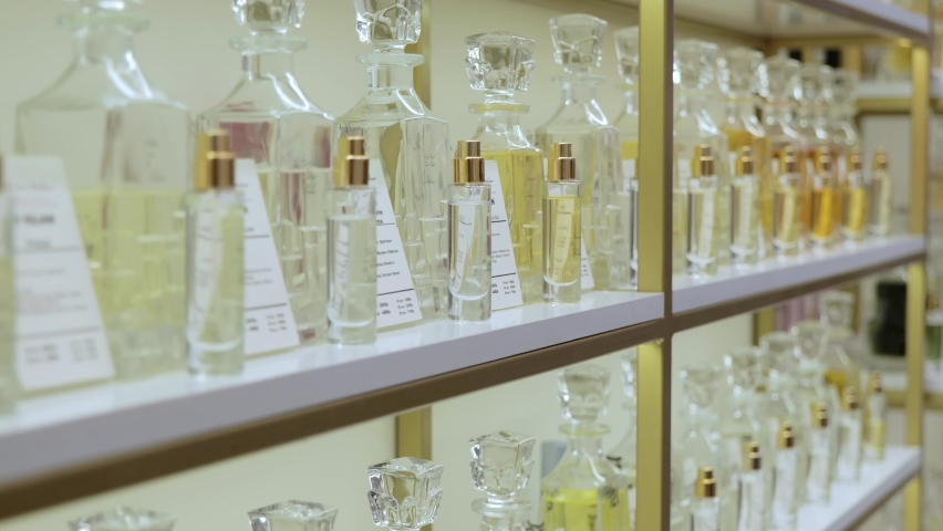 Large selection of body fragrances. Perfume rack. Luxurious perfume in a cosmetics store. Choosing the right scents. Women's shopping in a boutique store Luxury | Shutterstock HD Video #1097762279