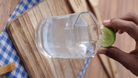 vertical video of Refreshing lemon water drink on table , top view 