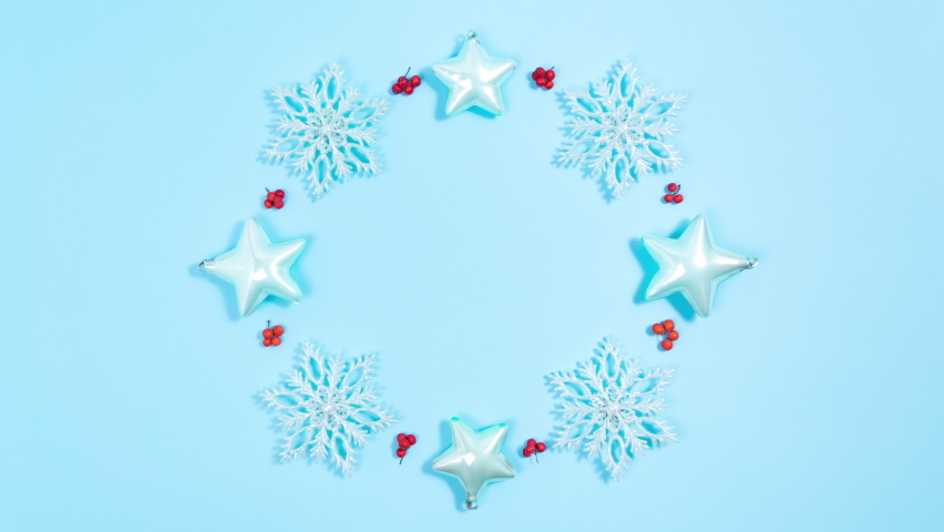 4k Christmas decorations of snowflakes and stars rotate, arranged in a circle along with red rowan berries. Blue background. Holiday greeting frame. Looping stop motion animation. Copy space. - Powered by Shutterstock - Get 15% off with code: PIKWIZARD15
