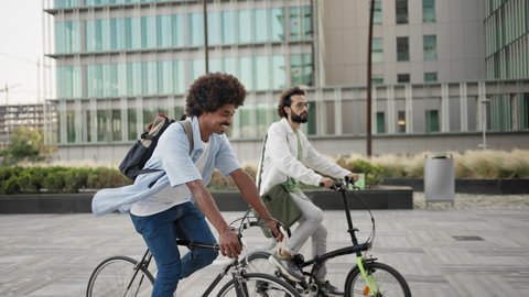 Happy casual business friends going to work with bicycle in the city  Video Stok