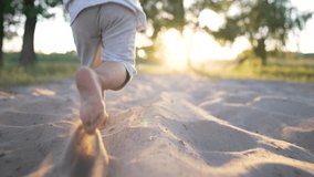 Feet running on the sand on beach. Child runs in the sun. Happy summer vacation. Child picnic in park. Bare feet of a toddler on the beach. Family vacation in nature. Cheerful kid playing in the park - Powered by Shutterstock - Get 15% off with code: PIKWIZARD15