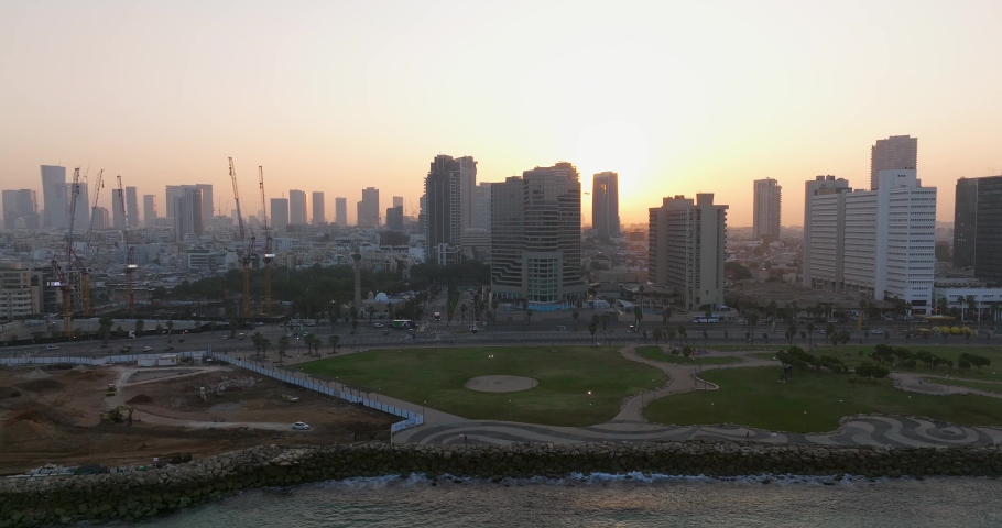 Tel Aviv coastline at sunrise with beautiful calm waters of The Mediterranean Sea, Waterfront hotels and light sun flare