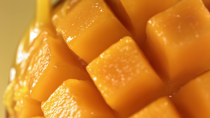 Slow Motion Shot of Mango Juice Splashing through Mango Cube Slices Royalty-Free Stock Footage #1097799025