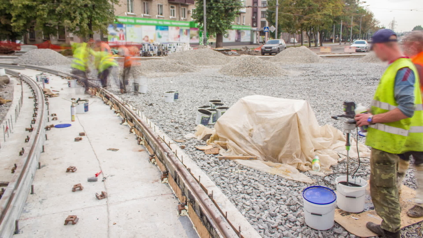 Workers install new tram rails on concrete plates during a reconstruction of the route timelapse. Filling by liquid resin for reduction of vibration and noice. Modernizations of tram tracks