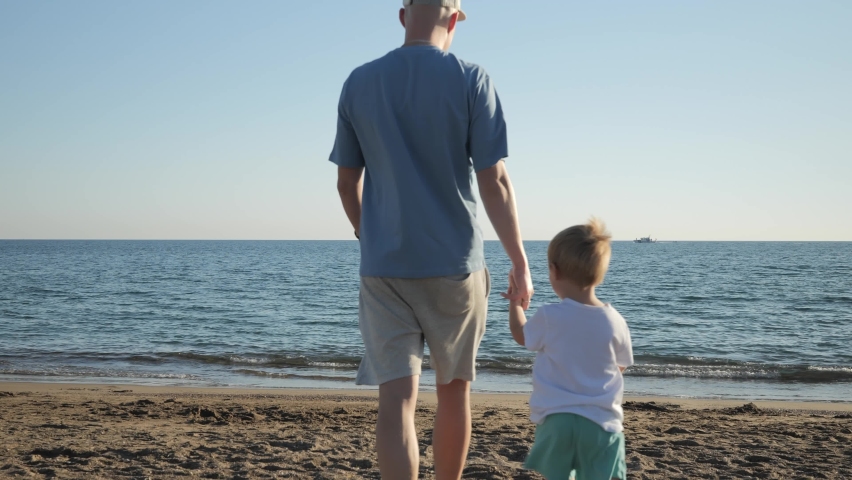 Father and son approach the beach to the sea. Father and son time together. A father's rest alone with his son, upbringing. High quality 4k footage Royalty-Free Stock Footage #1097804027