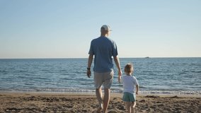 Father and son approach the beach to the sea. Father and son time together. A father's rest alone with his son, upbringing. High quality 4k footage - Powered by Shutterstock - Get 15% off with code: PIKWIZARD15