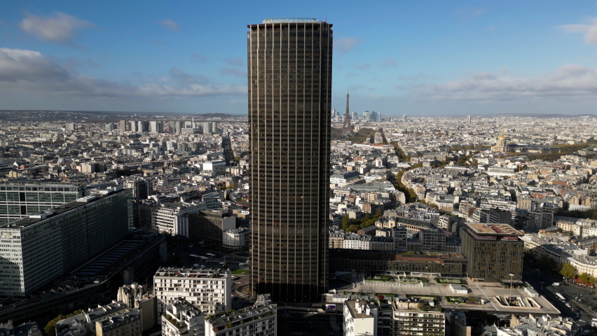Montparnasse tower with Tour Eiffel in background, Paris in France. Aerial cinematic backward