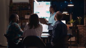 African american employee presenting report, showing charts on laptop screen. Company research statistics presentation, diverse team discussing analytics, planning sales strategy - Powered by Shutterstock - Get 15% off with code: PIKWIZARD15