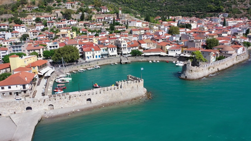 Aerial drone video of iconic fortified port and medieval castle uphill in historic city of Nafpaktos, Aitoloakarnania, Greece