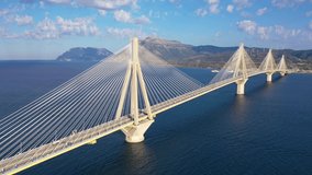 Aerial drone video of famous state of the art modern cable strait bridge of Rio Antirio crossing corinthian gulf from Peloponnese seaside city of Rio to Antirio - mainland Greece