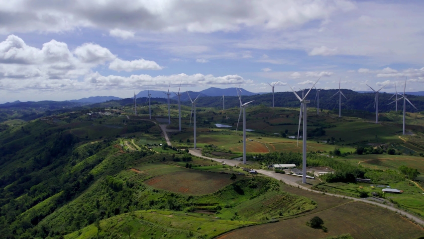 Wind Power Turbines, Aerial view of powerful Wind turbine farm for energy production on beautiful cloudy sky, Wind power turbines generating clean renewable energy for sustainable development. Royalty-Free Stock Footage #1097817481