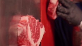 Vertical Screen: Chef hands making a heart shape form raw fresh beef meat ribeye. Juicy fresh meat steak on board with different meat goods around.