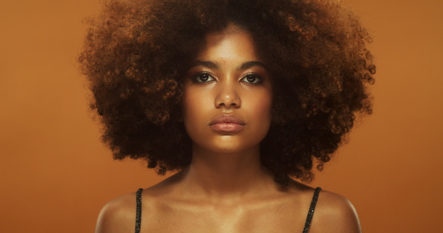 Beauty portrait of african woman with beautiful curly brown hair, afro hairstyle, isolated on beige background Royalty-Free Stock Footage #1097817947