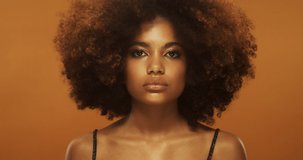 Beauty portrait of african woman with beautiful curly brown hair, afro hairstyle, isolated on beige background