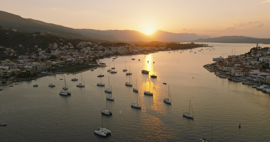 Poros island Greece. Many sailing yachts are anchored in marina at Aegean sea Aerial view of drone slide on beautiful panorama of golden sailing yachts high mountains of sea harbors. Travel. Tourism Royalty-Free Stock Footage #1097821817