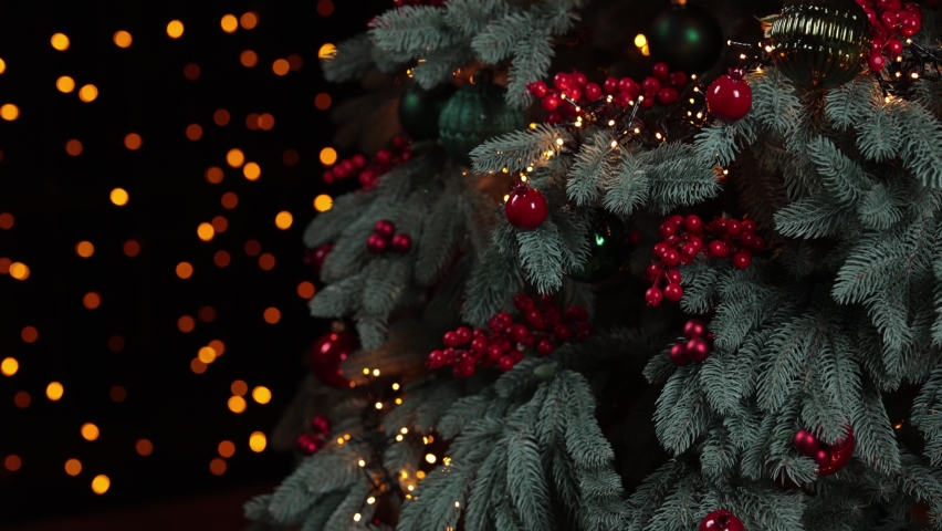 Beautiful green branches of winter fir tree with magic holiday lights of Christmas garlands. Abstract Xmas or New Year holiday 4k video background