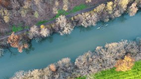 Aerial drone footage of four-person rowing boat (coxless four) on a river in autumn