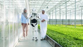 Arab successful businessman walking and muslim wife in hijab with scientific robot with artificial intelligence holding tablet in greenhouse. Agricultural cyborg working in horticultural sphere. - Powered by Shutterstock - Get 15% off with code: PIKWIZARD15
