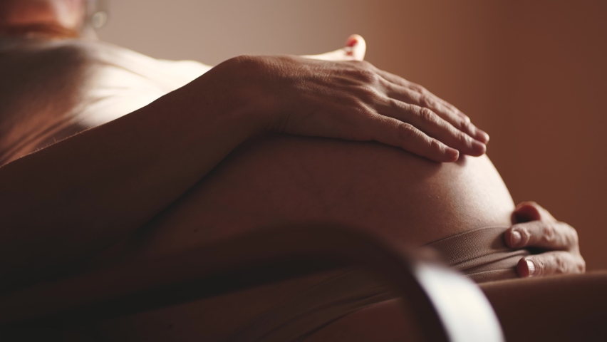 pregnant woman. health pregnancy motherhood procreation concept. close-up belly of a pregnant woman. woman sunlight waiting for a newborn baby. pregnant woman holding her belly indoors