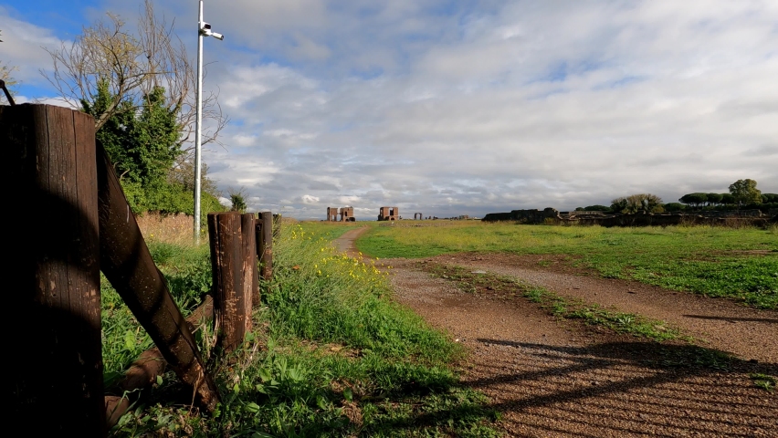 Ancient Roman structures and stone monuments line the roadsides of the Via Appia Antica in Rome Italy