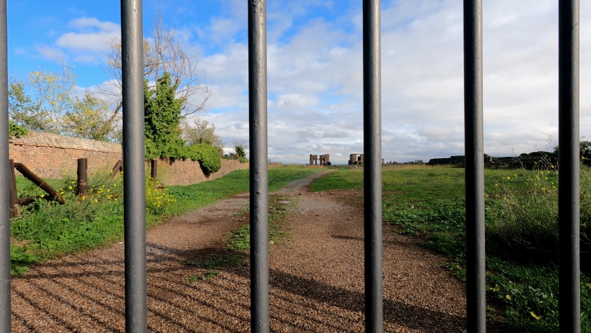 Ancient Roman structures and stone monuments line the roadsides of the Via Appia Antica in Rome Italy
