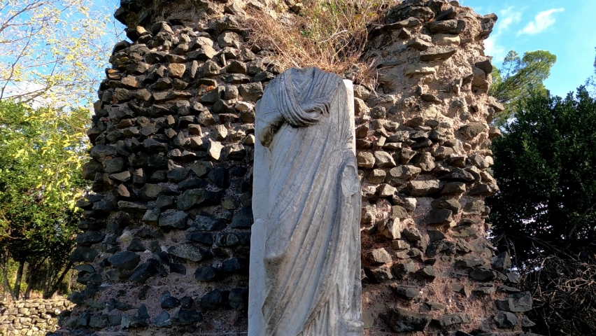 Ancient Roman structures and stone monuments line the roadsides of the Via Appia Antica in Rome Italy