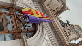 Flags of Spain, the Valencian Community and the European Union on the balcony facade of the Valencia City Hall. Vertical video.