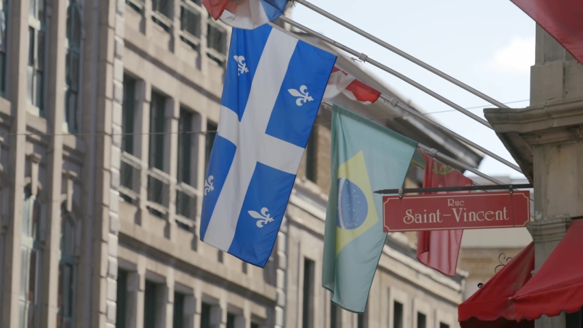 Flag Of Quebec And Brazilian Flag On The Exterior Of A Business Building At The Corner Of Rue Saint-Vincent In Old Montreal, Quebec, Canada. closeup