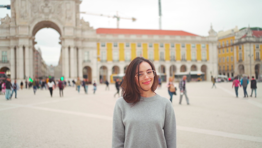 Caucasian brunette Woman in eyeglasses standing city street. Smiling Adult Elegant Lady stand outdoors. Stylish person in glasses middle shoot teeth gummy smile. Commerce square in lisbon 